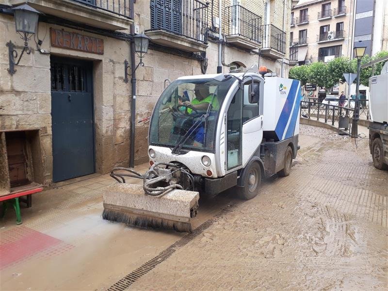 Photo of cleaning machinery doing work on a muddy street